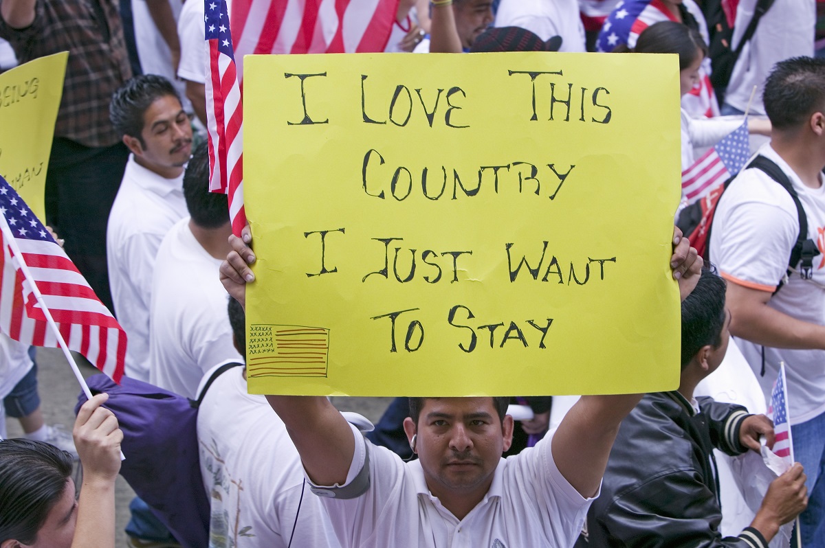 Supporter holds sign paths to legal status for undocumented