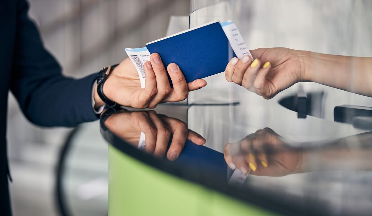 Woman exchanges travel documents with immigration officer